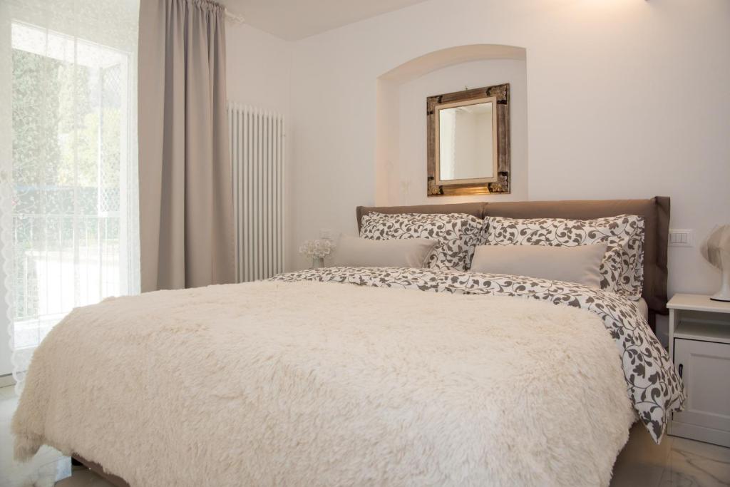 リーヴァ・デル・ガルダにあるResidenza Romanticaのベッドルーム1室(大型ベッド1台、壁に鏡付)