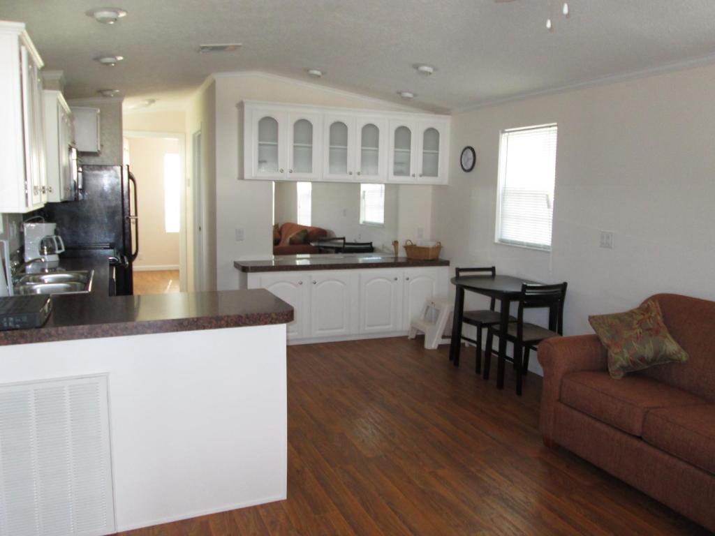 cocina y sala de estar con sofá y mesa en Southern Palms Park Model 4, en Fort Mason