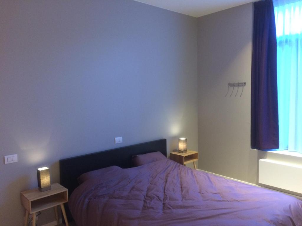 a bedroom with a bed and two lamps on tables at ChilloutOostende in Ostend
