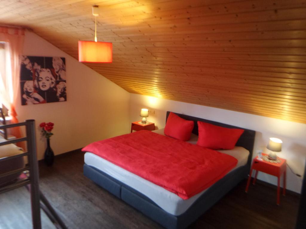 um quarto com uma cama com almofadas vermelhas em Ferienwohnung Glückskinder em Rust