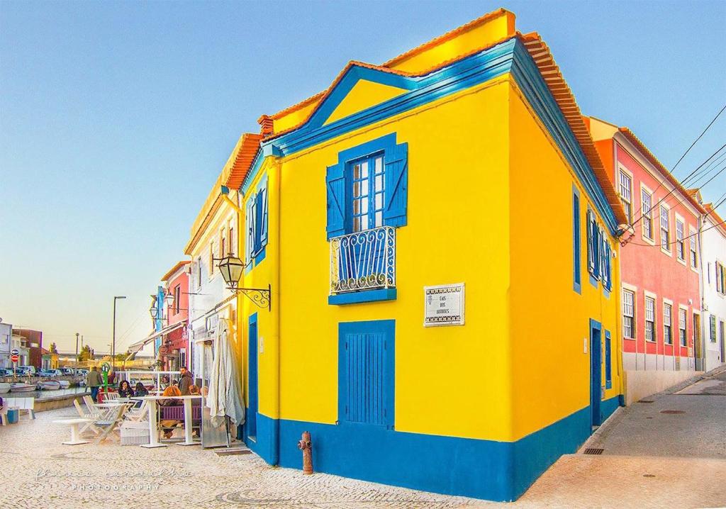 un edificio amarillo y azul al lado de una calle en Casa do Mercado, en Aveiro