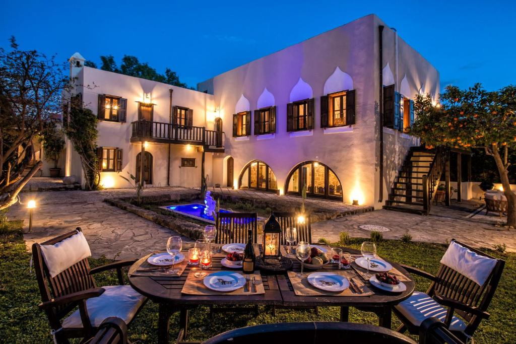 une table à manger extérieure en face d'une maison dans l'établissement Lemuria Manor, Wine Dark Sea Villas, à Rhodes