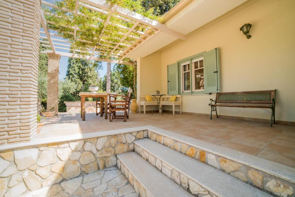 a patio with a stone wall and a pergola at Villino Guest House in Akrotiri