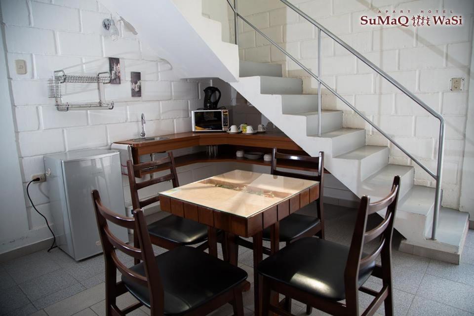 ein Esszimmer mit einem Tisch, Stühlen und einer Treppe in der Unterkunft Sumaq Wasi Apart Hotel in Tacna