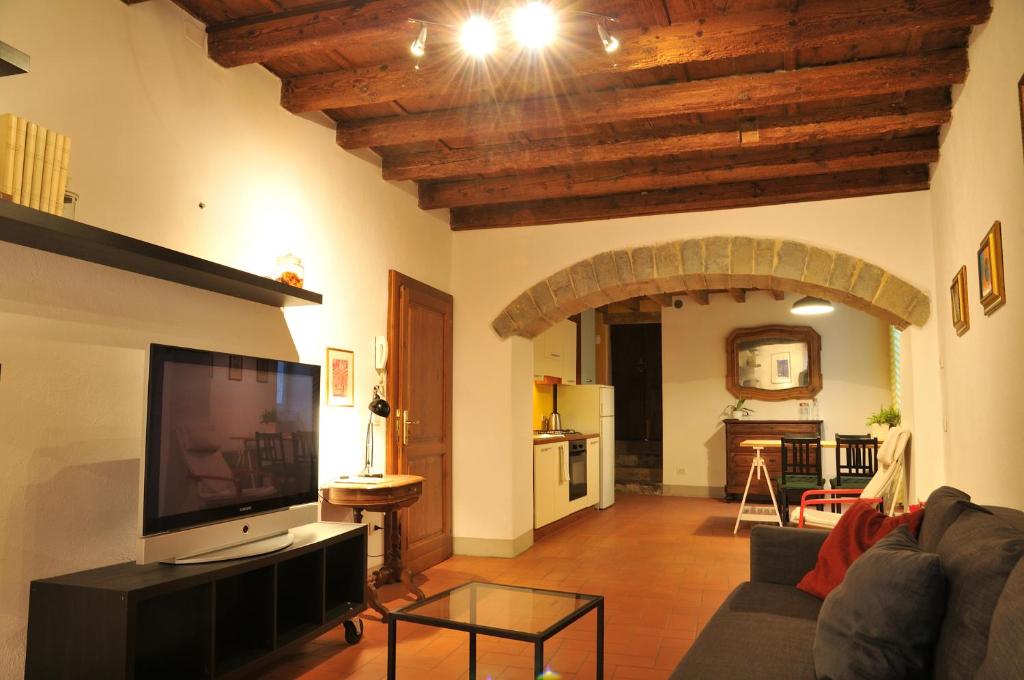 a living room with a couch and a tv and a kitchen at FEEL - Arco Antico in Bergamo