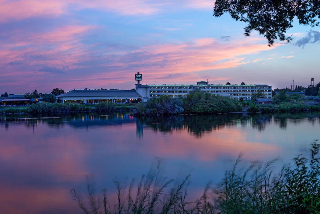 um grande edifício ao lado de uma massa de água em Shilo Inn Suites - Idaho Falls em Idaho Falls