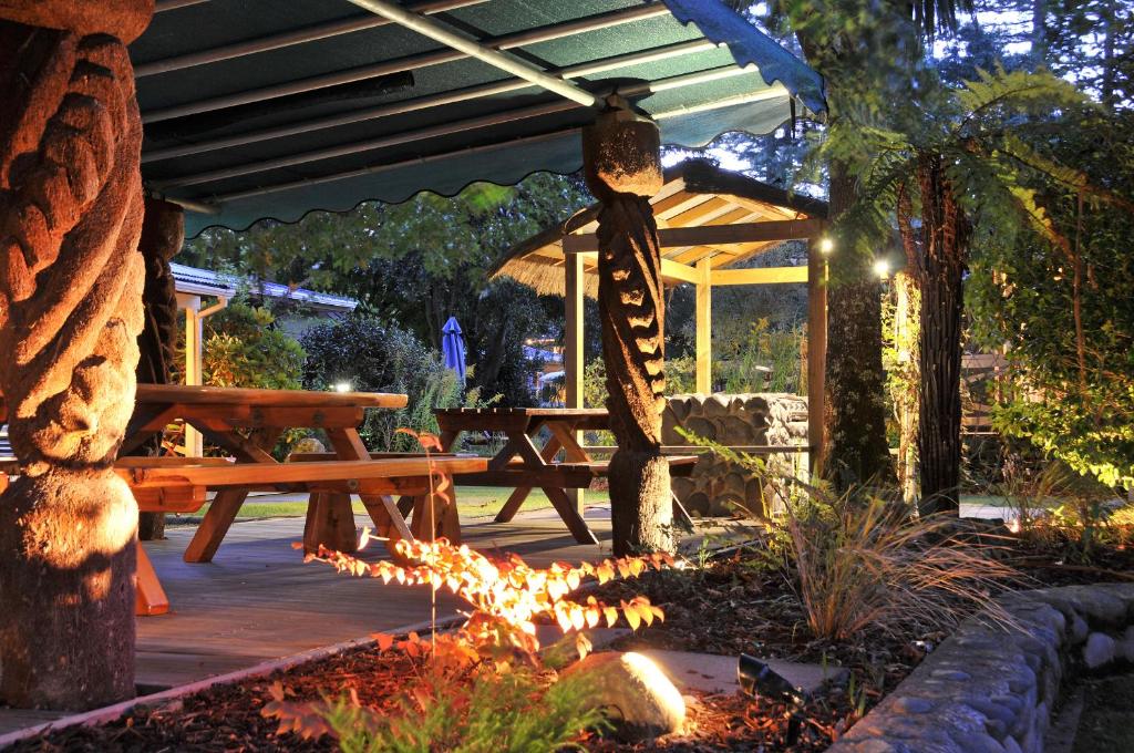 a wooden deck with a picnic table and a fire pit at Creel Lodge in Turangi