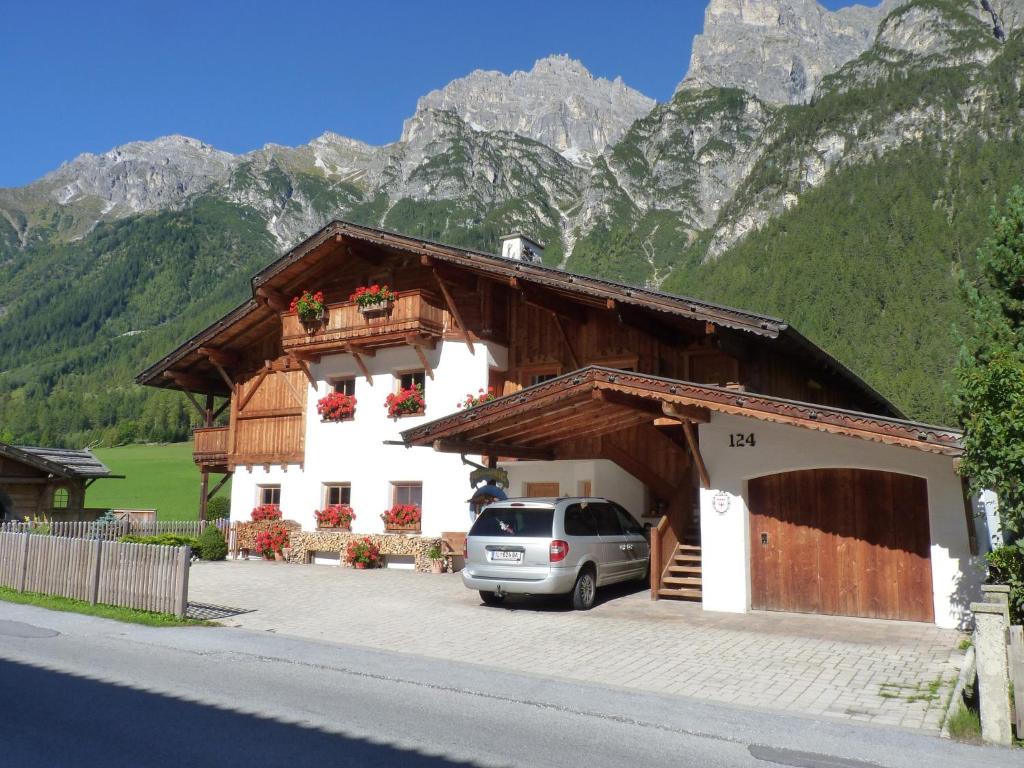 um carro estacionado em frente a um edifício com montanhas em Conny's Ferienwohnungen em Gschnitz