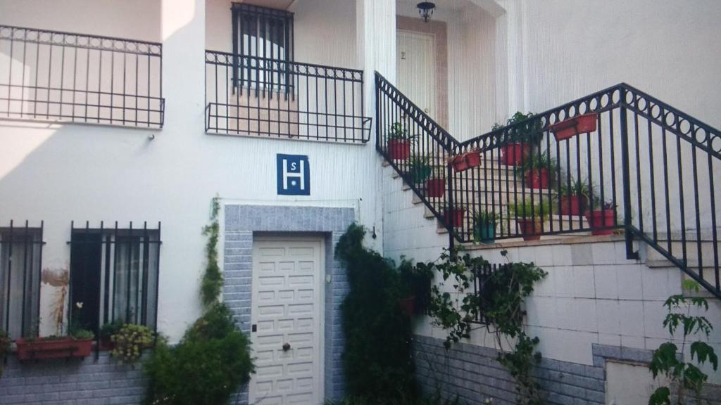 メリダにあるHostal Alamedaの階段と植物が立つ白い建物