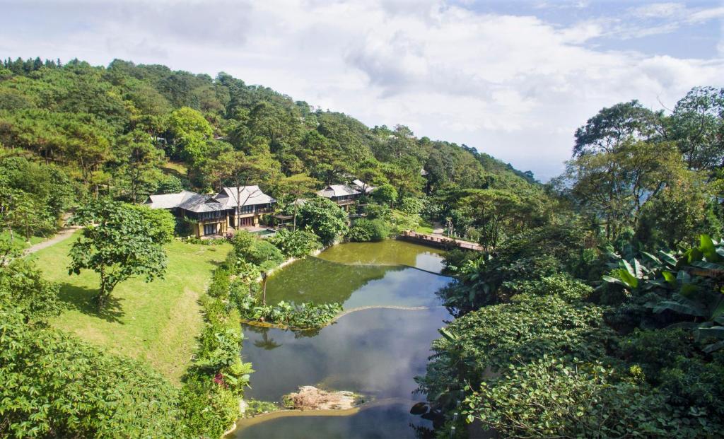 een luchtzicht op een huis op een heuvel naast een rivier bij Melia Ba Vi Mountain Retreat in Hanoi