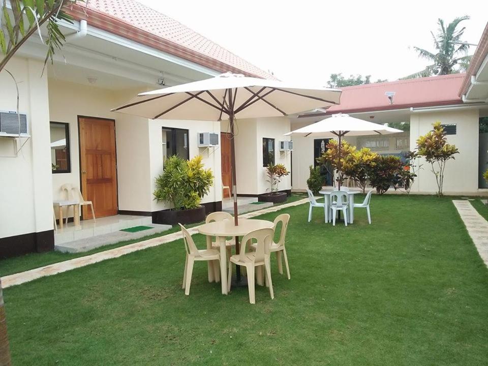 a patio with tables and chairs and umbrellas at Mingche Apartment in Panglao