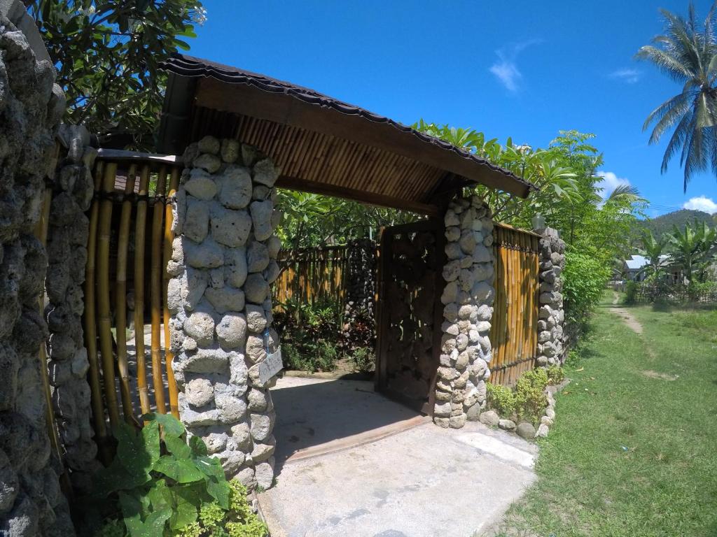 una puerta a un edificio de piedra con una valla en Khoo Villa en Senggigi 