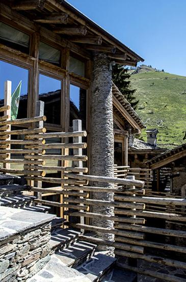 a log cabin with a fence in front of it at Agriturismo Valliera in Castelmagno