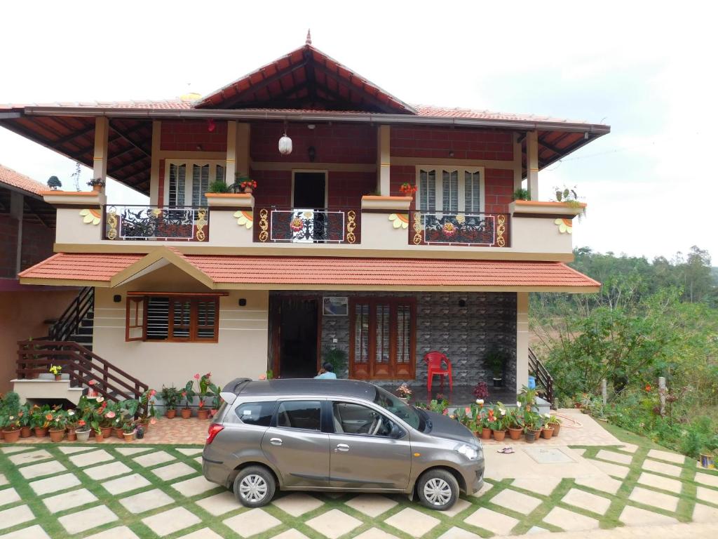 a small car parked in front of a house at Cauvery Homestay in Somvārpet