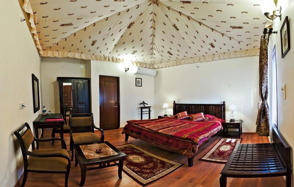 una camera da letto con un letto, un tavolo e delle sedie di Lohana Village Resort a Pushkar