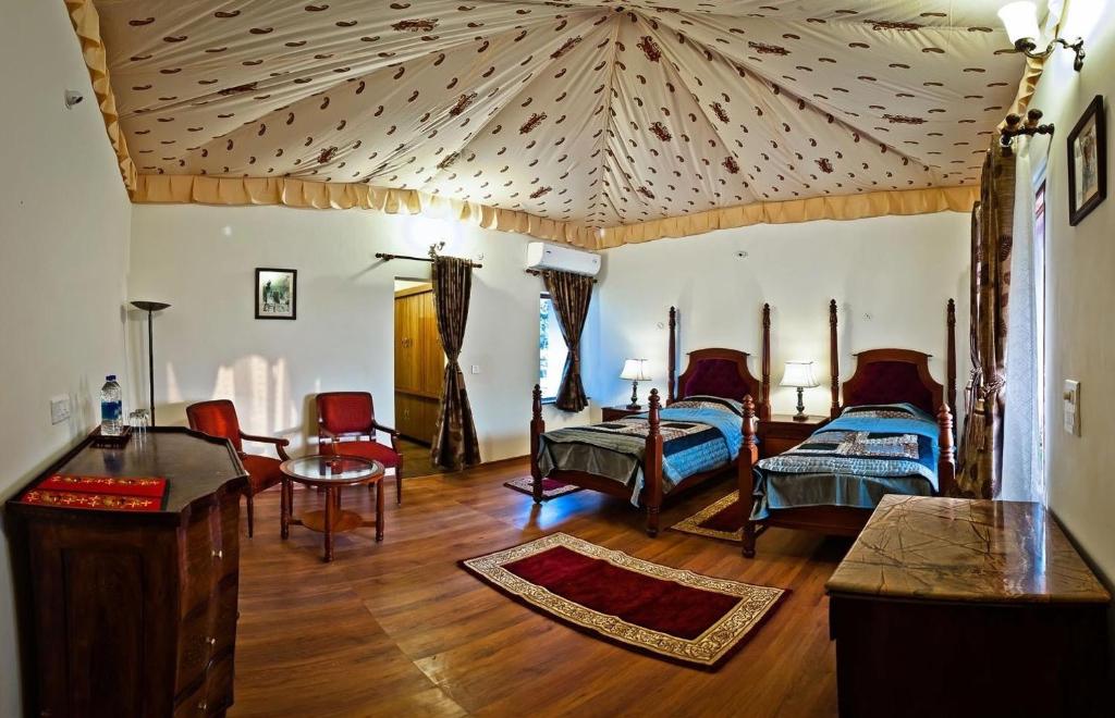 普什卡的住宿－Lohana Village Resort，一间卧室设有两张床和格子天花板