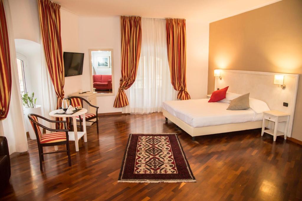 Habitación de hotel con cama, mesa y sillas en Inn Rome Rooms & Suites, en Roma