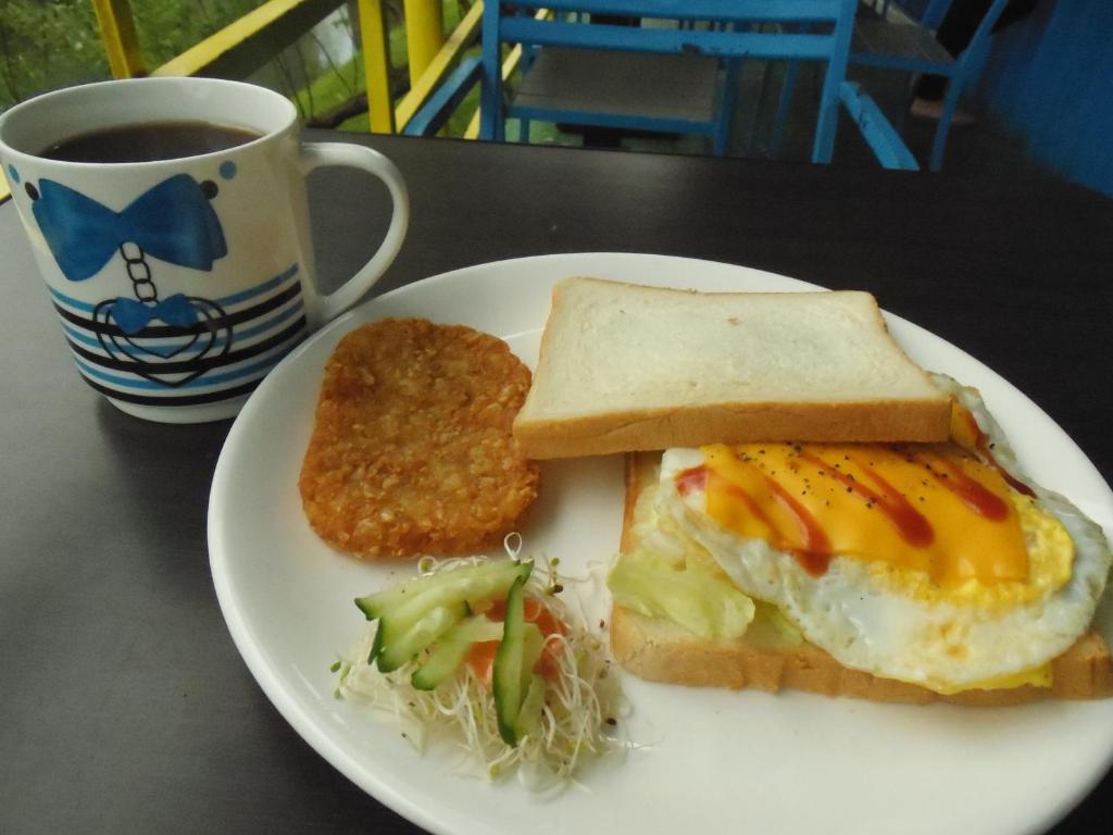 a plate of food with a sandwich and a cup of coffee at Relax heart B&amp;B in Dongshan