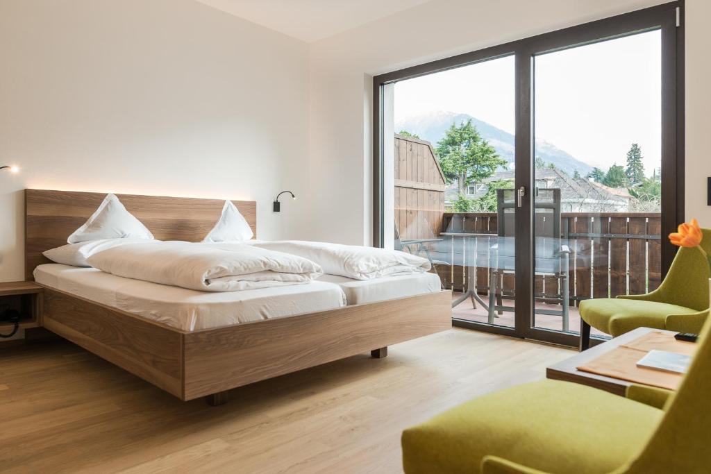 een slaapkamer met een bed en een groot raam bij Hotel Salgart in Merano