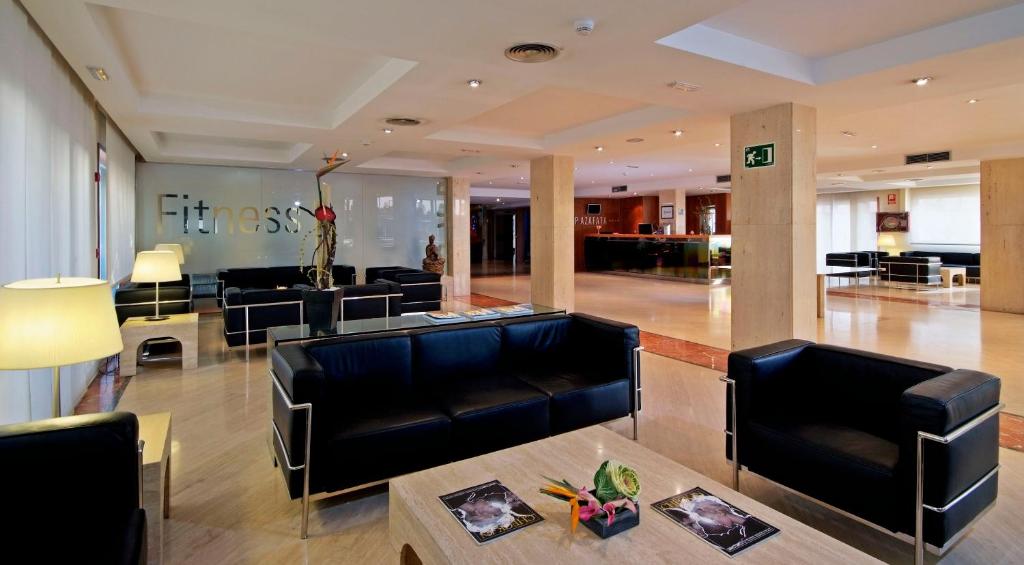 a lobby with black leather furniture in a building at Port Azafata Valencia in Manises