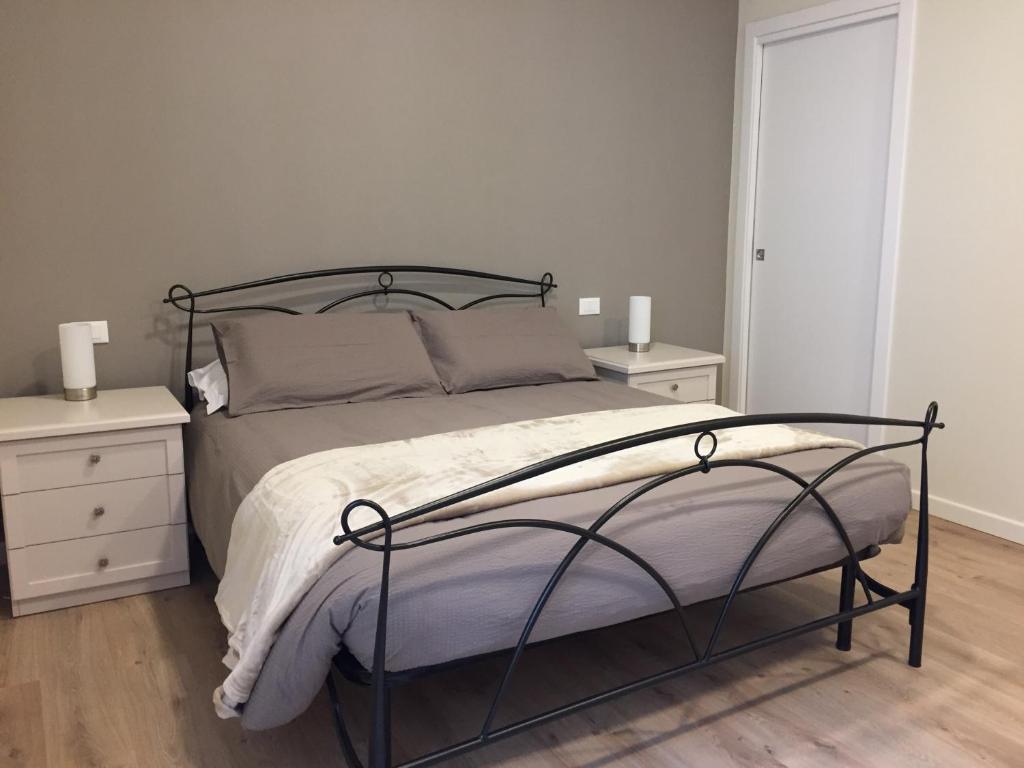 een slaapkamer met een bed met 2 nachtkastjes en 2 lampen bij B&B VESTA in Brescia