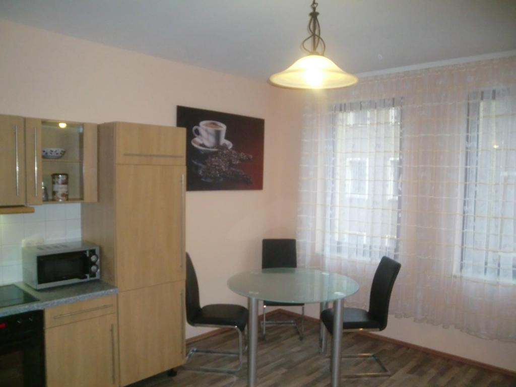 a kitchen with a table and chairs and a table and a microwave at City Apartment in Nürnberg am Bahnhof in Nuremberg
