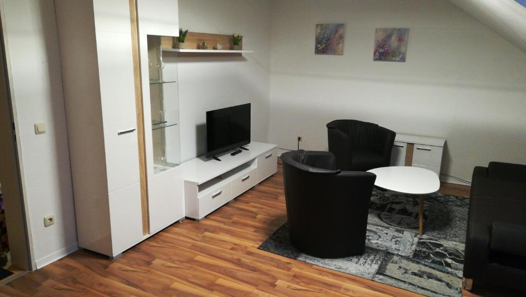 - un salon avec une télévision, une table et des chaises dans l'établissement Apartment 28 o M, à Castrop-Rauxel
