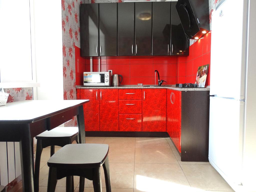 トゥーラにあるInndays on Liteinaya 22aの赤いキャビネットと赤い壁のキッチン