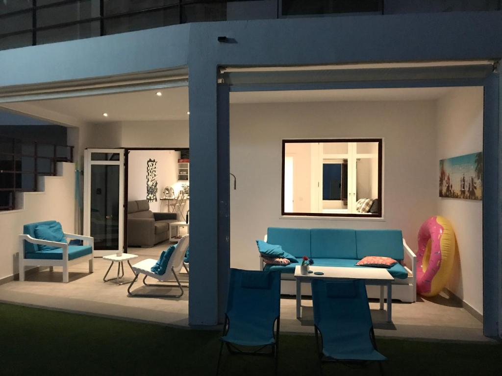 uma sala de estar com um sofá azul e cadeiras em Apartments Rachel Paradise em Puerto Rico de Gran Canaria