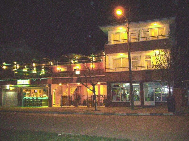 un edificio con una luz de la calle delante de él por la noche en NELLY Guest House, en Ravda