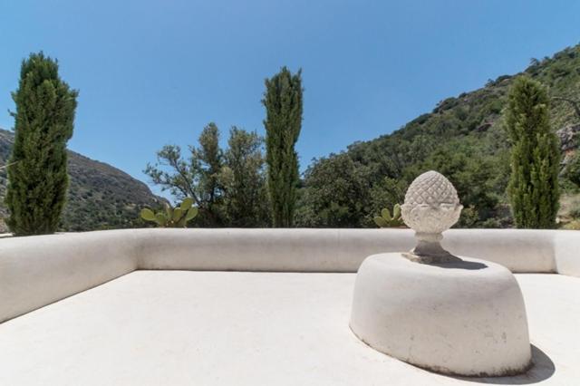 uma estátua de pedra sentada em cima de um telhado em Relax in a natural park em Lerápetra