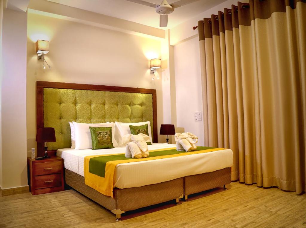 Un dormitorio con una cama grande con dos animales de peluche. en Vendol Maliga Edge, en Kandy
