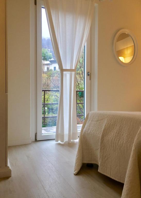 a bedroom with a bed and a large window at Hotel Du Parc in Stresa
