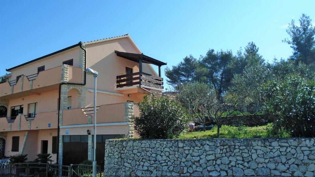 um edifício com uma parede de pedra em frente em Apartmani A.Teskera em Trogir