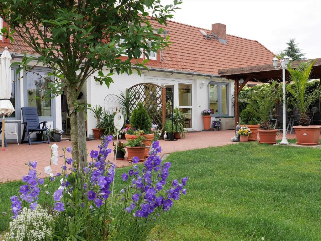 a house with purple flowers in the yard at Hübsches Appartement in Am Salzhaff mit Kamin in Rakow