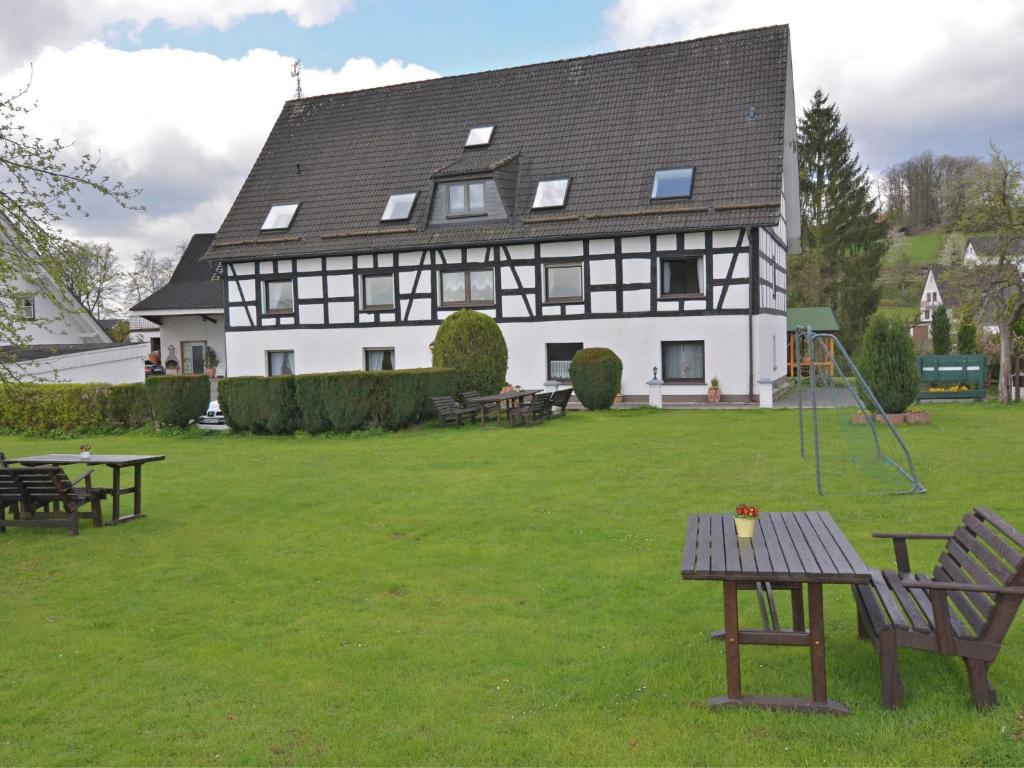 a large white house with a picnic table in the yard at Flat with private pool in Sauerland in Attendorn