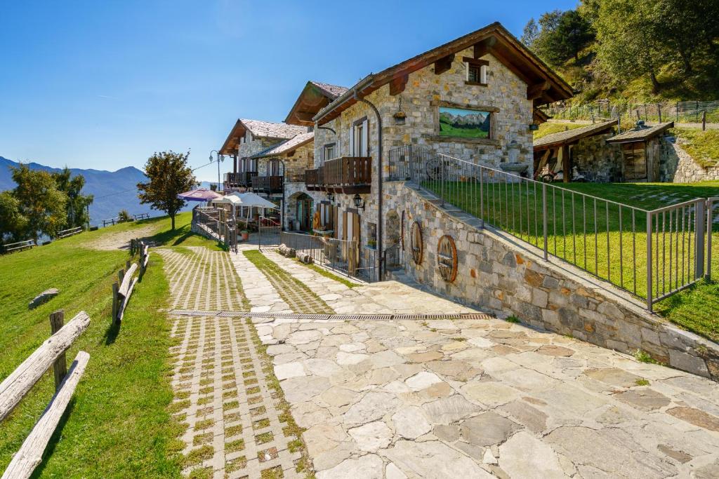 un edificio de piedra en una colina junto a una casa en Agriturismo Giacomino en Gera Lario