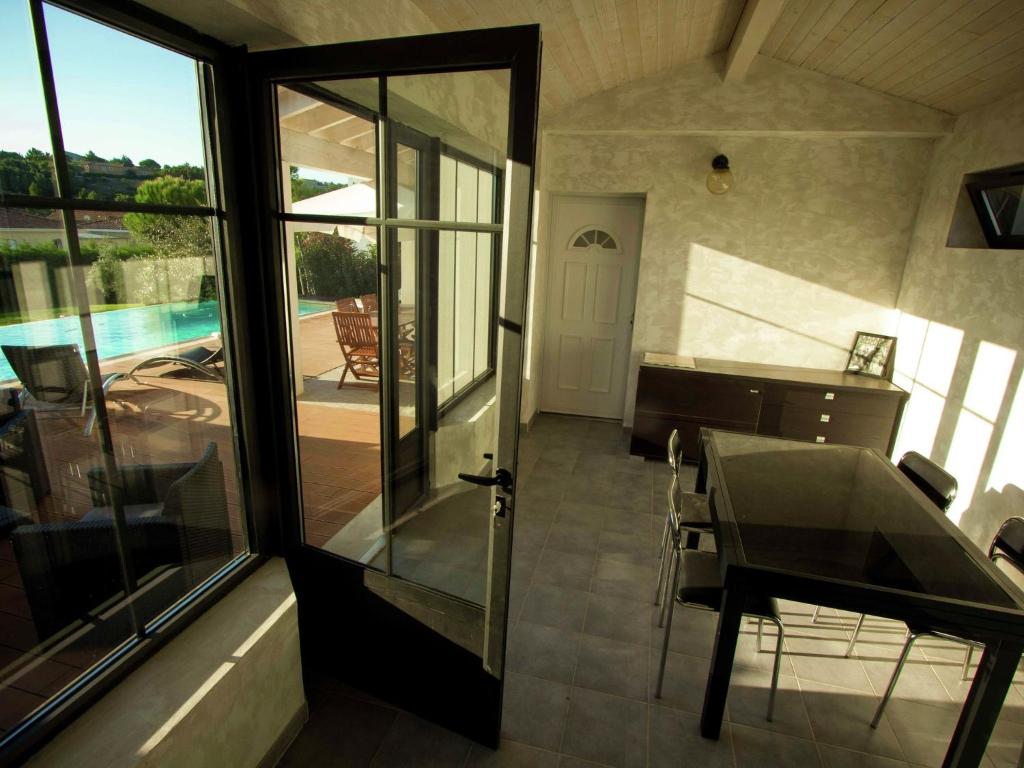 une maison avec vue sur la piscine et une porte en verre dans l'établissement Narbonne Holiday Home with Pool, à Narbonne