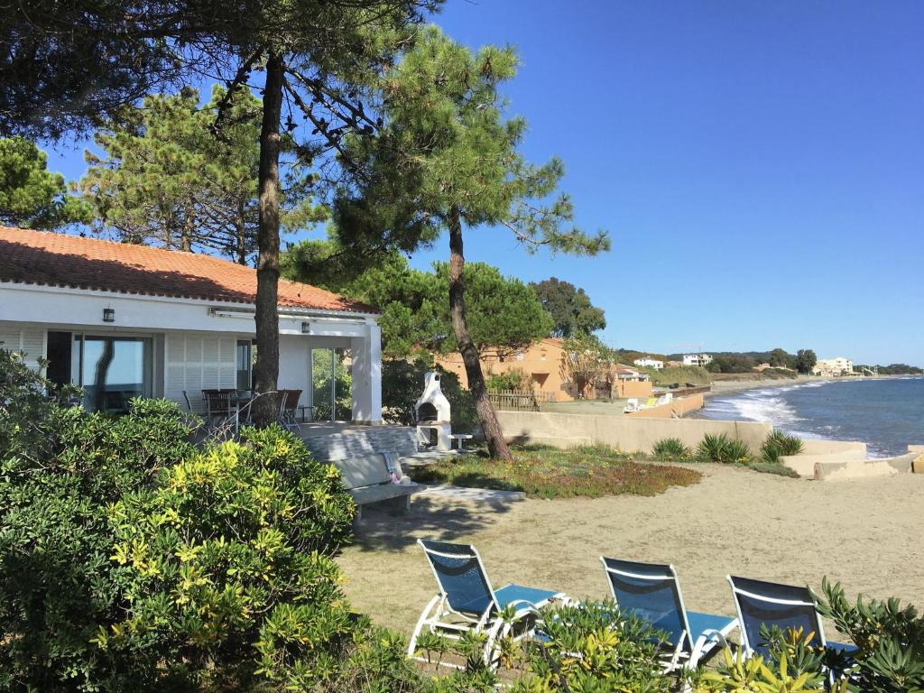 a group of chairs on the beach near a house at Attractive Villa in Moriani Plage at Sea in San-Nicolao