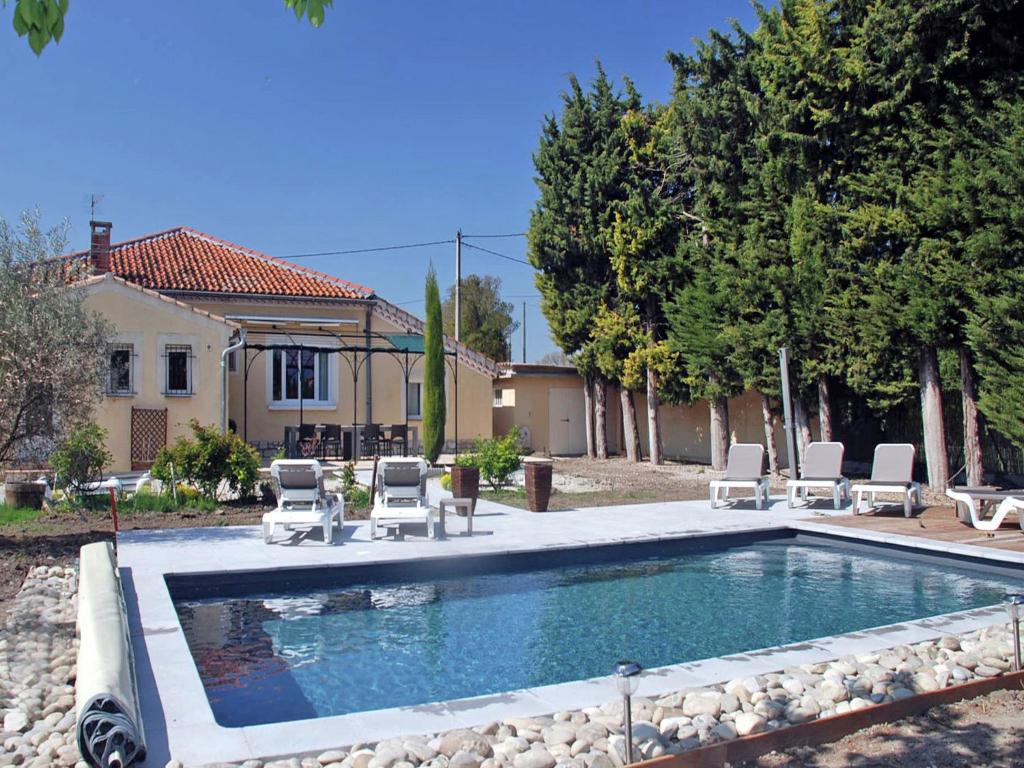 リル・シュル・ラ・ソルギュにあるSpacious Holiday Home in Provence with Private Poolのスイミングプール(椅子付)と家