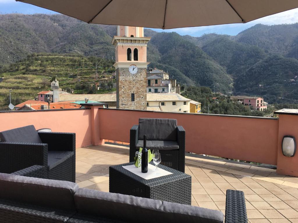 un patio avec des chaises et une tour d'horloge sur le toit dans l'établissement 1886 Casa Medone, à Levanto