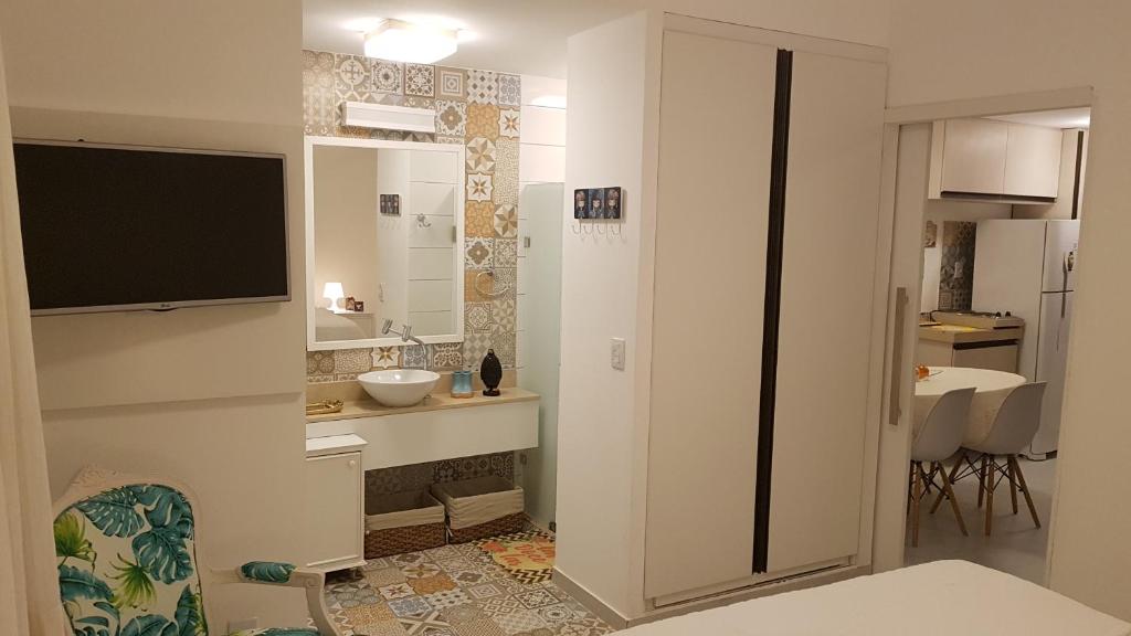 a white bathroom with a sink and a mirror at Solar Água Pipa 119 in Pipa