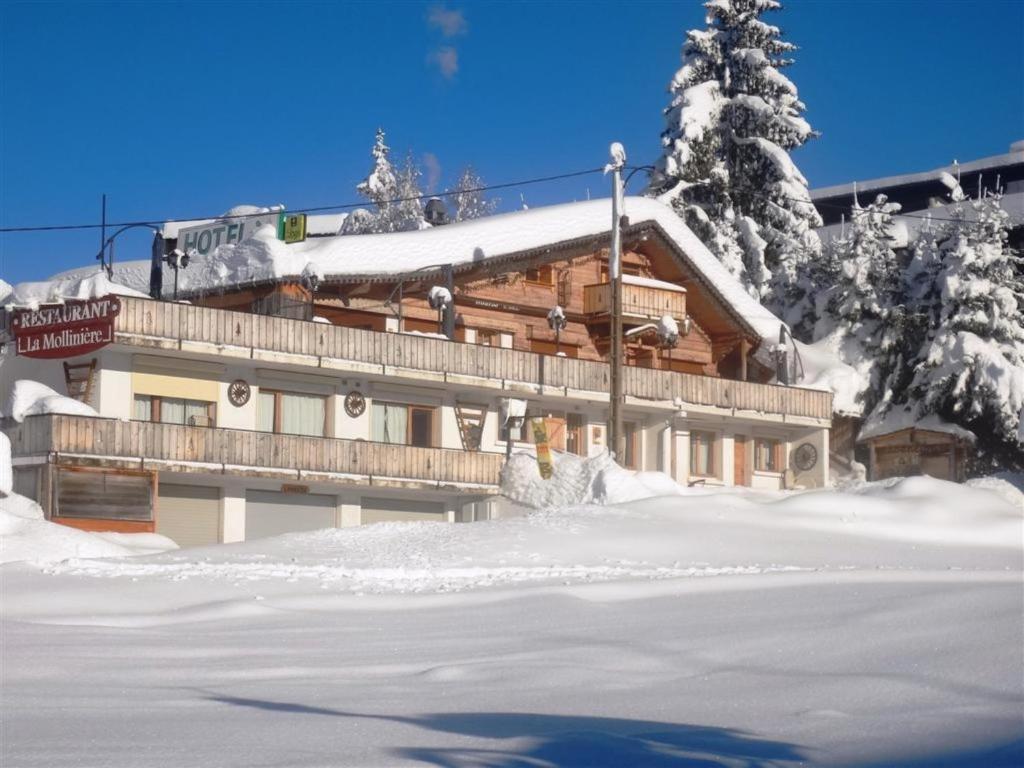 un grand bâtiment avec de la neige devant lui dans l'établissement La Mollinière, à Notre-Dame-de-Bellecombe