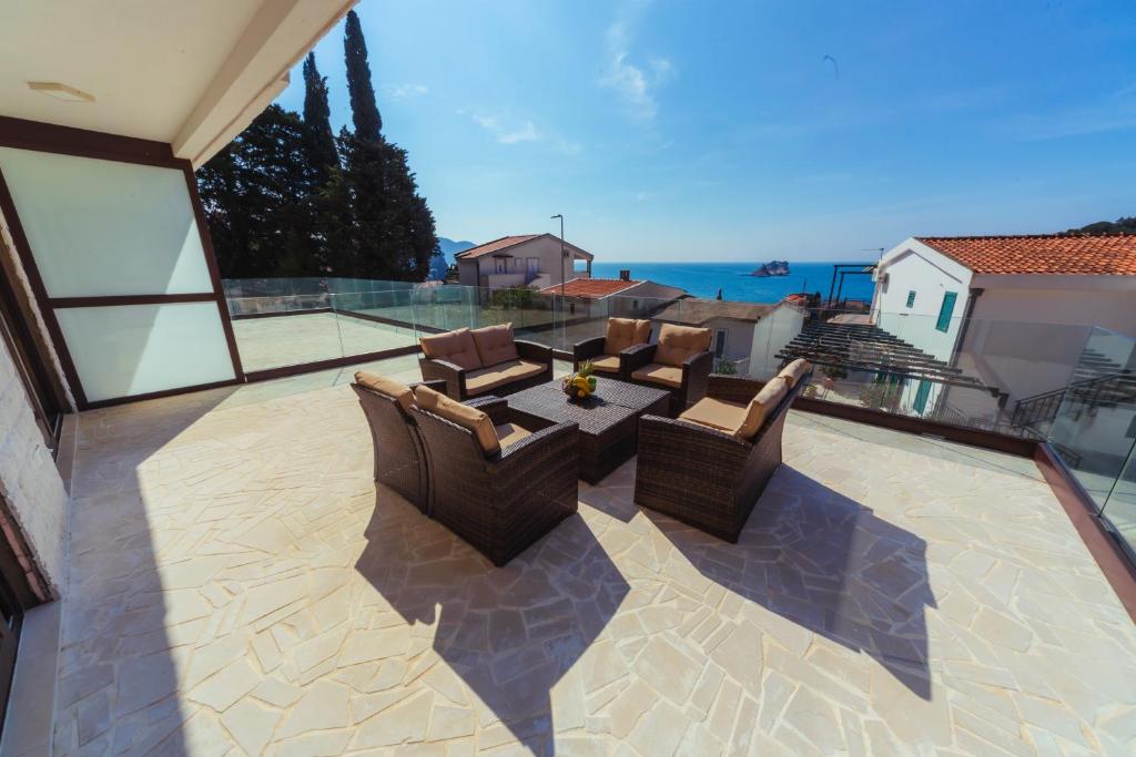 a patio with chairs and a table on a balcony at Apartments Monte Re in Petrovac na Moru