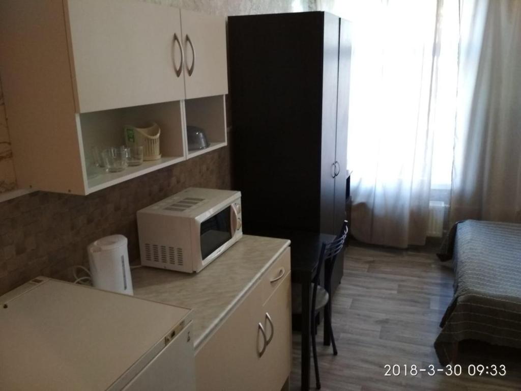 a small kitchen with a microwave on a counter at Griboedova 110 in Saint Petersburg