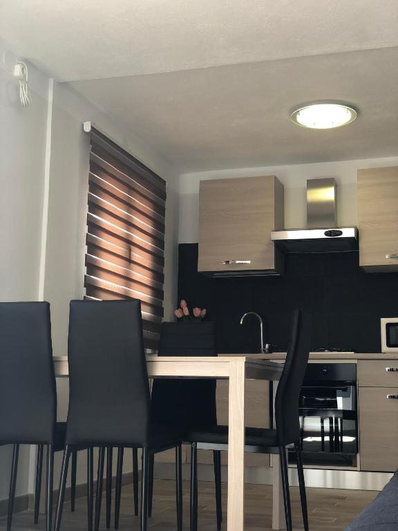 a kitchen with a dining table and black chairs at Villa hortencia in Tarragona