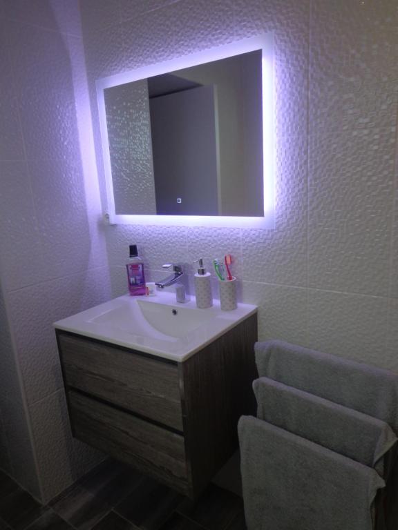 a bathroom with a sink and a mirror and a chair at Casa Vista da Marquesa in Nordeste