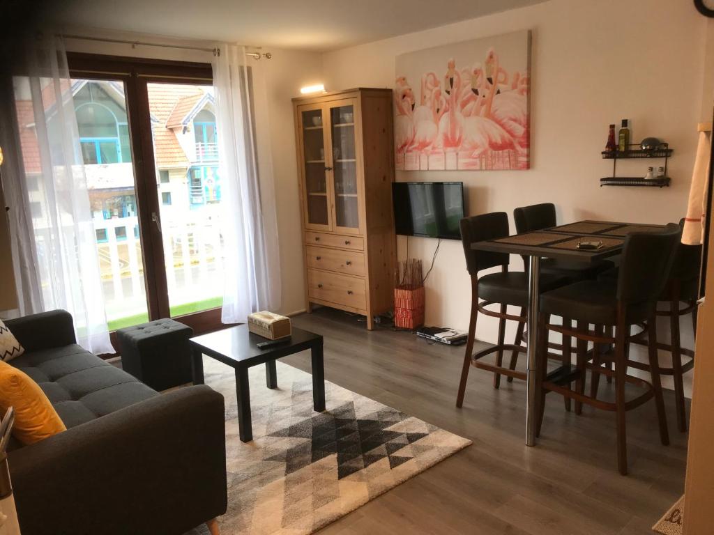 a living room with a couch and a dining room table at Pilatre de Rosier proximité plage in Wimereux