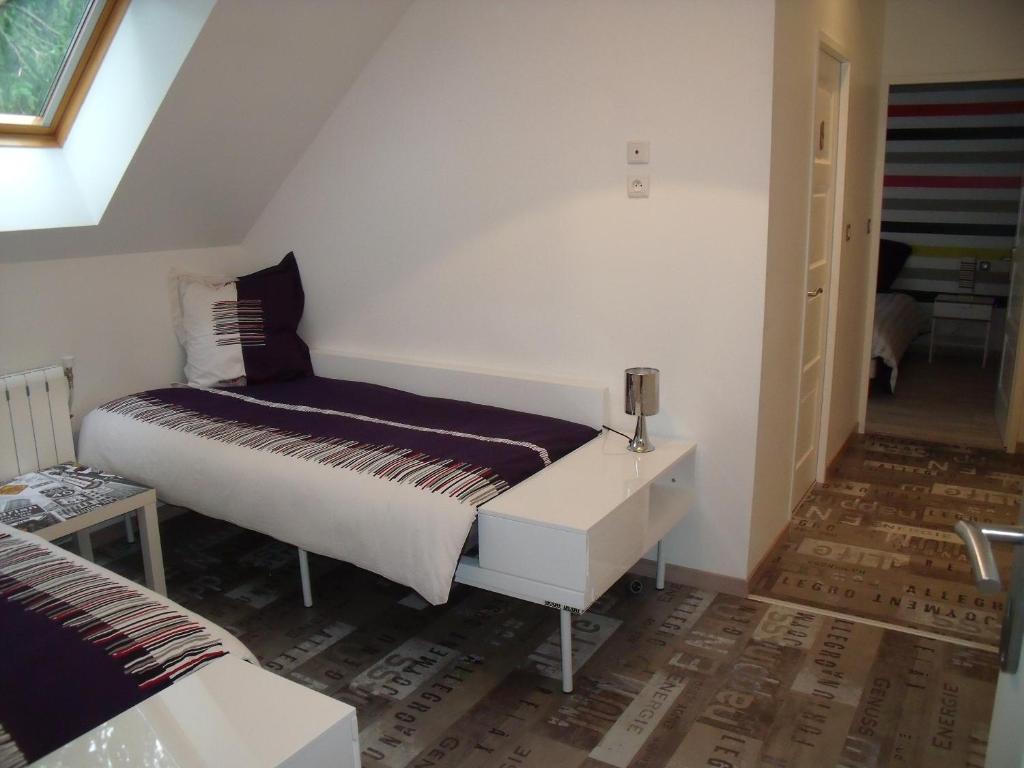 une petite chambre avec un lit et une table dans l'établissement au clair de lune, à Mehun-sur-Yèvre