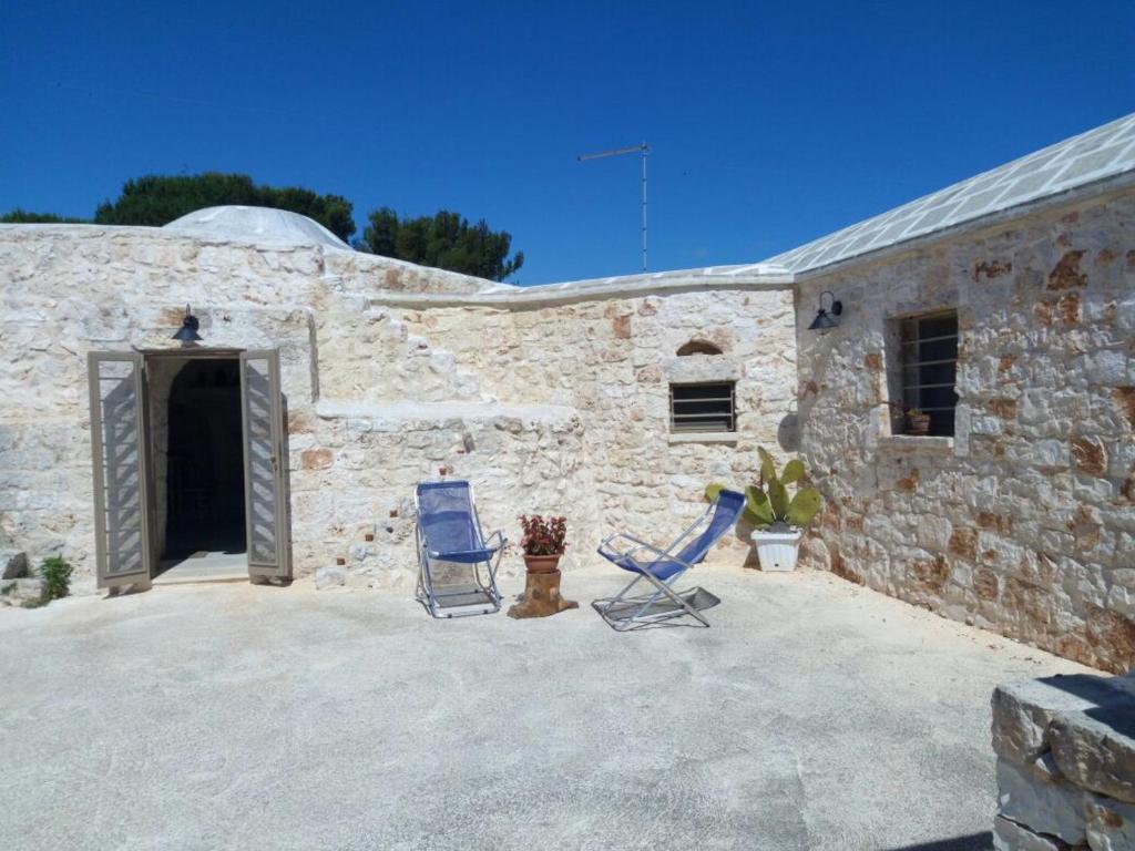 a patio with two chairs and a building at Trullo saraceno in Ostuni